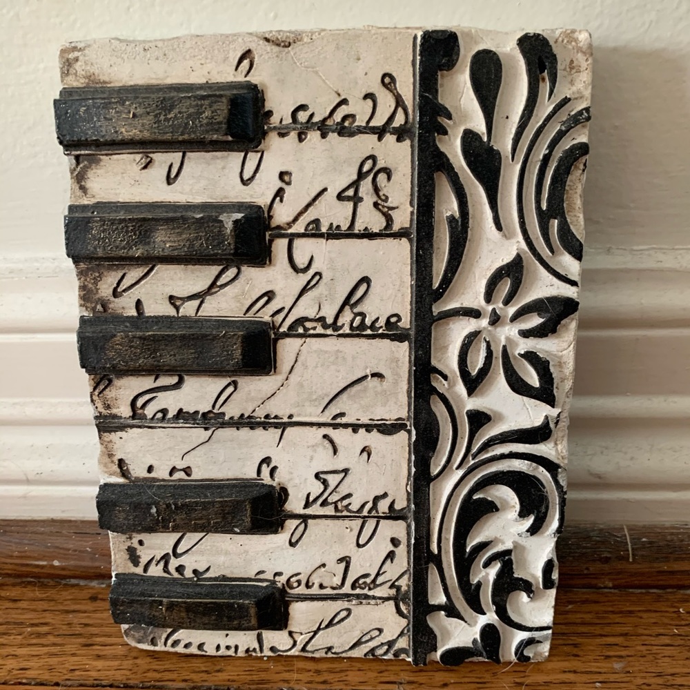 hanging wall piece with piano keys and designs